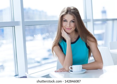 Portrait Of A Beauty Young Woman With A Tea Cup Sitting In A Coffe Shop