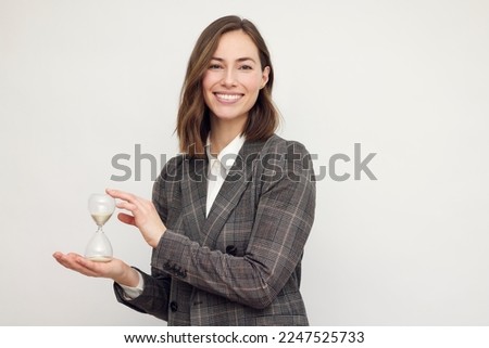 Portrait of beautyful and confident business woman smiling with hour glass	