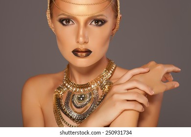 Portrait of a beautyful woman with golden makeup wearing jewelry, Egyptian Style Woman