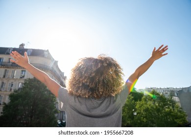 Portrait From Behind Young African American Woman With Arms Raised Outdoors