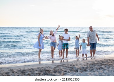 portrait of a big happy family, parents with children are relaxing on the seashore