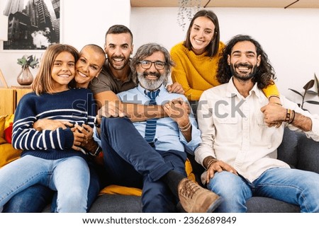 Portrait of big multi generational happy family. Photo group of grandfather, mother, father, aunt, ancle and granddaughter sitting together on sofa at home