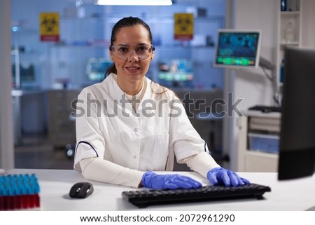 Portrait of biochemist researcher typing biochemistry expertise on computer working at medical experiment in microbiology hospital laboratory. Therapist doctor developing vaccine against coronavirus ストックフォト © 