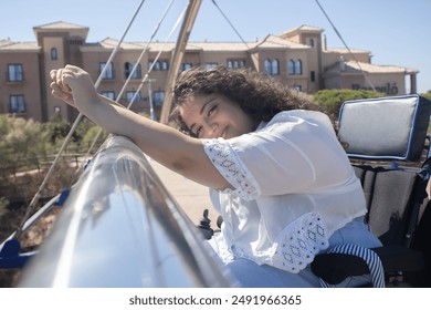 Portrait of a biracial girl posing on a bridge smiling in a wheelchair - Powered by Shutterstock