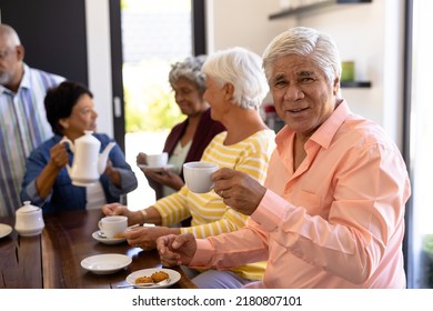 Portrait Of Biracial Senior Man Having Coffee And Cookies With Multiracial Friends At Table. Snacks, Drink, Food, Unaltered, Friendship, Togetherness, Support, Assisted Living And Retirement Home.