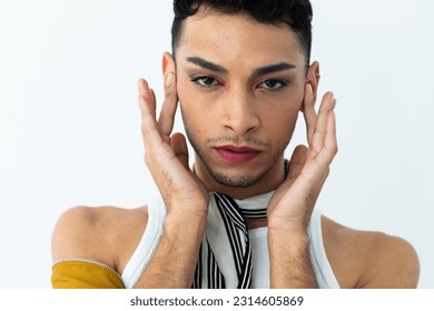 Portrait of biracial transgender man wearing make-up, looking at camera on white background. Gender, fashion and lifestyle, unaltered. - Powered by Shutterstock