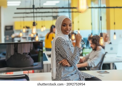 Portrait Of A Black ( African-American) Female Muslim Standing In A Modern Business Office While Wearing A Hijab.