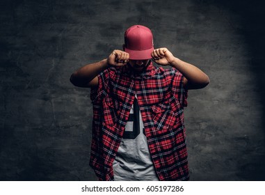 Portrait of Black bearded male dressed in a red fleece shirt and a cap over grey background. - Shutterstock ID 605197286