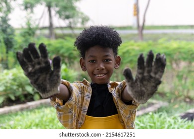 Portrait of black boy in farmer's outfit raising two hands