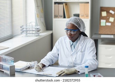 Portrait Of Black Female Scientist Filling In Charts While Working In Medical Laboratory, Copy Space