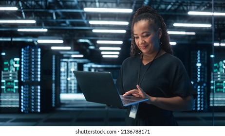 Portrait of Black Female Specialist Using Laptop in Big Data Center. Managing Director Working Attentively. Technology Science Breakethrough. Progress and Innovation concept - Powered by Shutterstock