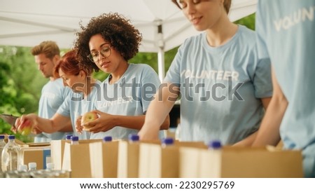 Portrait of a Black Latina Female Volunteer Preparing Free Food Delivery for Low Income People. Charity Workers and Members of the Community Work Together in Local Humanitarian Aid Donation Center.