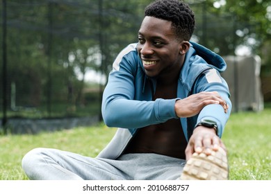 Portrait of black male stretching in a park. He is stretching legs. - Shutterstock ID 2010688757