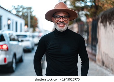 Portrait Of A Black Man With A Beard And Hat Posing On The Street