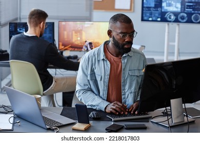 Portrait of black man using computer while writing software code in office, copy space - Shutterstock ID 2218017803