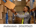 Portrait of black man worker working in large warehouse retail store industry factory. Rack of stock storage. Cargo in ecommerce and logistic concept. Depot. People lifestyle. Shipment service.