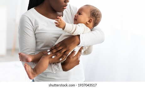 Portrait Of Black Mother Holding Crying Baby On Hands