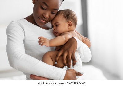 Portrait Of Black Mother Holding Crying Baby On Hands