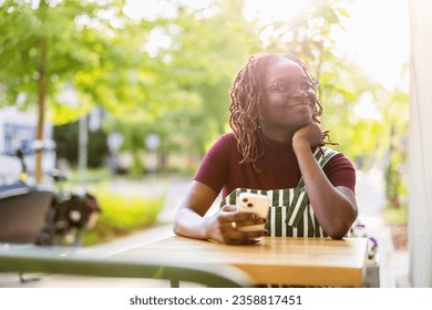 Portrait of a black non-binary person sitting in an outdoor cafe
 - Powered by Shutterstock