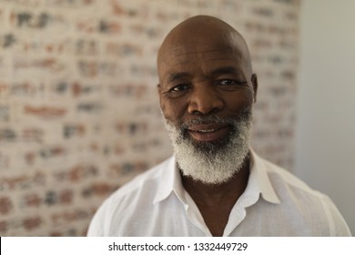 Portrait of black senior man smiling and standing at home