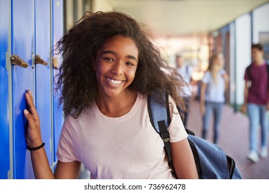 Portrait Of Black Teenage Girl By Lockers In School Corridor