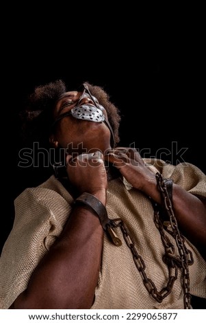 Portrait of a black woman in chains with an iron mask on her fac