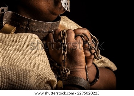 Portrait of a black woman with chains on her hands and an iron mask on her face representing the slave Anastacia. Slavery in Brazil.
