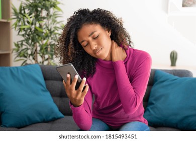 Portrait Of Black Woman Feeling Neck Pain Using Cellphone