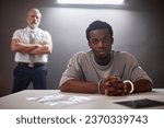 Portrait of Black young man as criminal looking at camera in prison with office standing in background, copy space