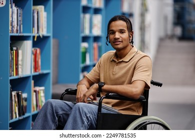 Portrait of black young man with disability in library setting at modern college smiling at camera - Powered by Shutterstock