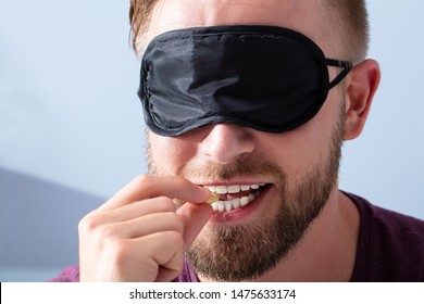Portrait Of Blindfolded Young Man Tasting Food