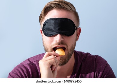 Portrait Of Blindfolded Young Man Tasting Food