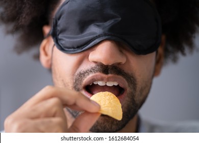 Portrait Of Blindfolded Young Man Testing Food