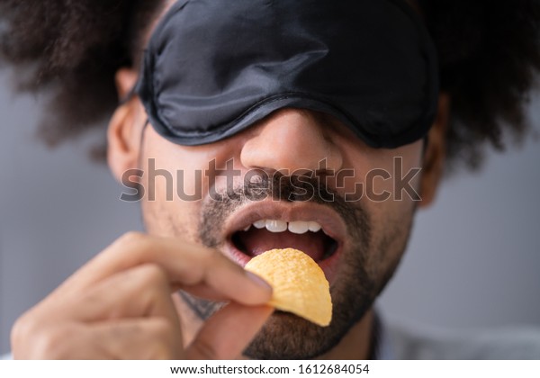 Portrait Of\
Blindfolded Young Man Testing\
Food