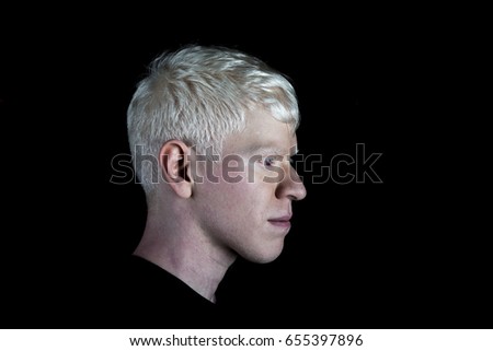 Portrait of blond man in profile, on black background
