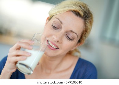 Portrait Of Blond Mature Woman Drinking Milk From Glass