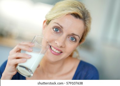 Portrait Of Blond Mature Woman Drinking Milk From Glass