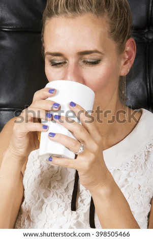 portrait of blond woman drinking from a white cup