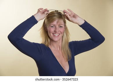 Portrait Of A Blond Woman In Low Cut Dress With Rimless Glasses