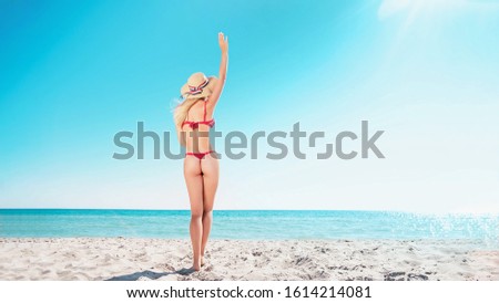 Portrait of a blonde in pink glasses at the sea. A woman walks along the beach and enjoys.