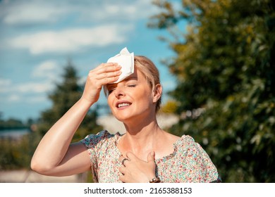 Portrait of Blonde pretty Woman having hot flash and sweating on sun heat at Summer day outdoors