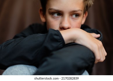 Portrait of blonde teenage boy on dark background outdoor. Low key close up shot of a young teen boy, adolescence. Selective focus. Loneliness, sadness, adolescent anxiety, emotional. - Powered by Shutterstock