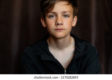 Portrait of blonde teenage boy on dark background outdoor. Low key close up shot of a young teen boy, adolescence. Selective focus. Loneliness, sadness, adolescent anxiety, emotional. - Shutterstock ID 2170282893