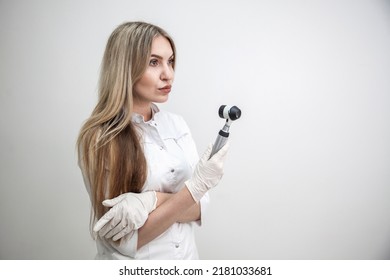Portrait of blonde woman dermatologist with dermatoscope in white lab coat and white gloves on the white background