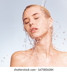 Portrait of blonde woman with drops of water on her face.  Photo of  young woman with clean skin and splash of water.Spa treatment. Girl washing her body with water. Water and body.