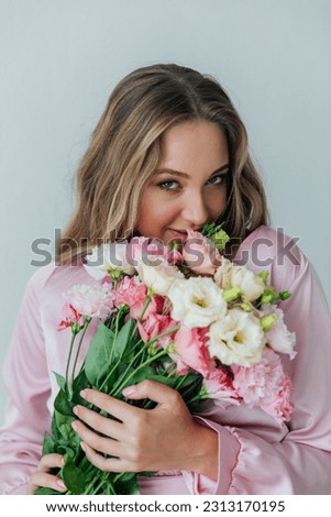 portrait of blonde woman with eustoma flowers on a white background