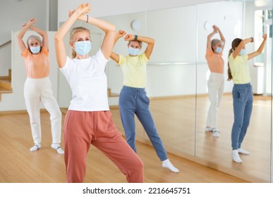 Portrait Of Blonde Woman In Face Mask Dancing During Group Class In Dance Studio