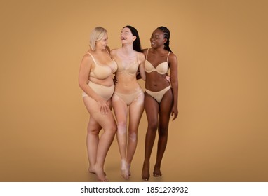 Portrait Of Body Positive Women Of Different Nationalities And Weight Types Posing On Beige Background, Full Length Shot Of Beautiful Black Female, Plus Size Woman, And Lady With Vitiligo In Underwear