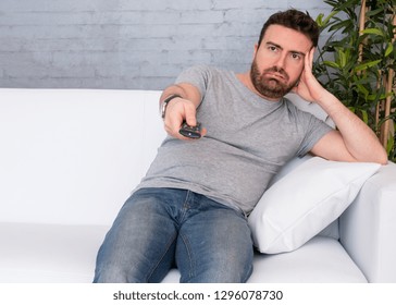 Portrait Of Bored Couch Potato Man Watching Television