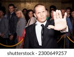 Portrait of bouncer with arm outstretched outside nightclub